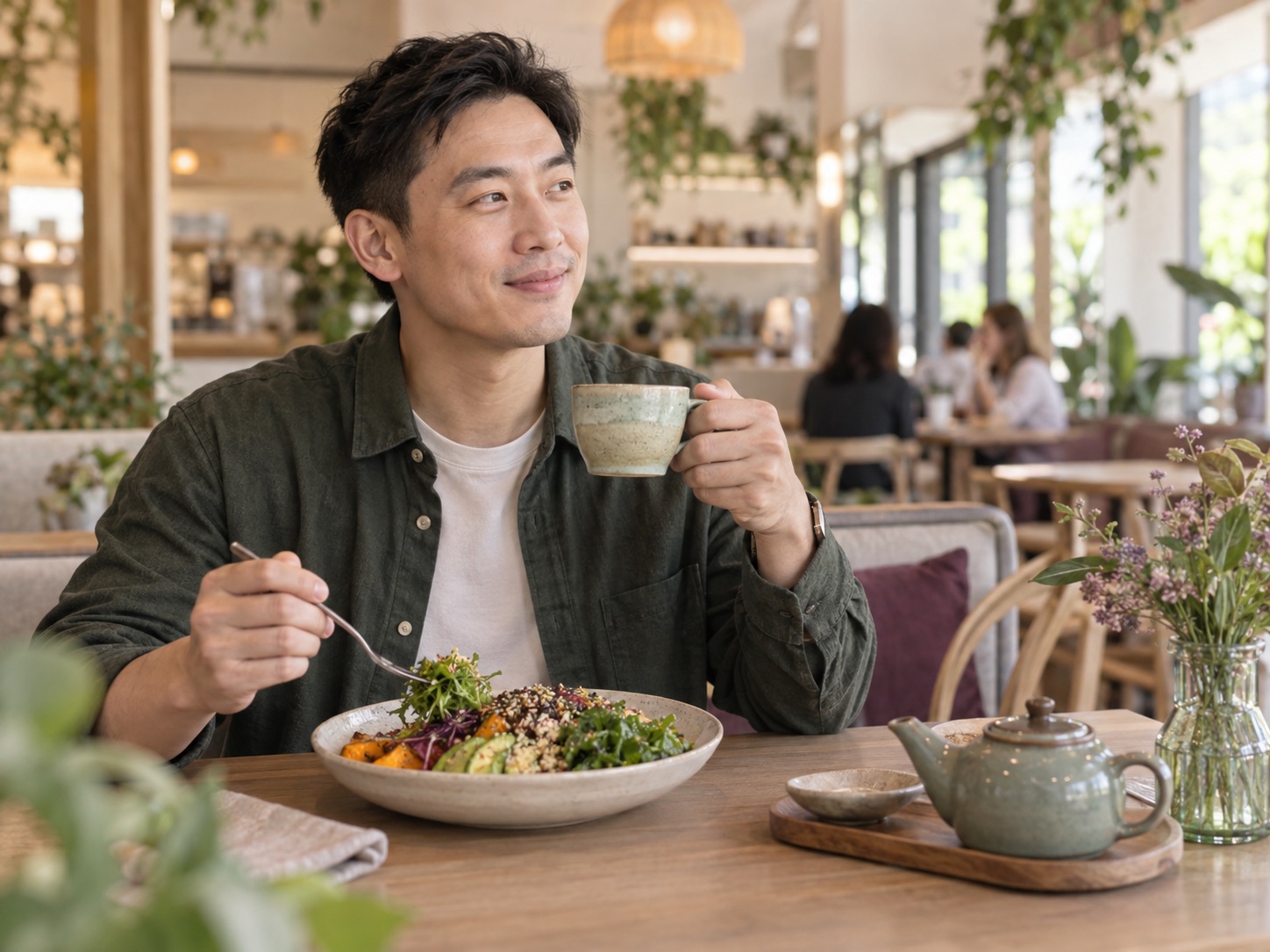 Chinese man enjoying a balanced meal and tea at a cafe